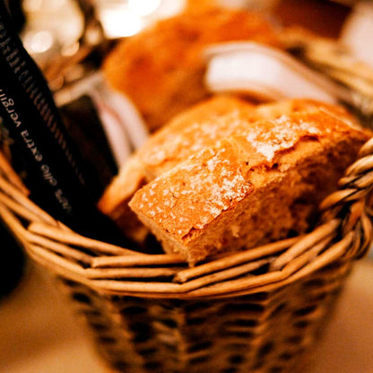 Rustic wicker bread basket with crusty artisan bread rolls at a restaurant