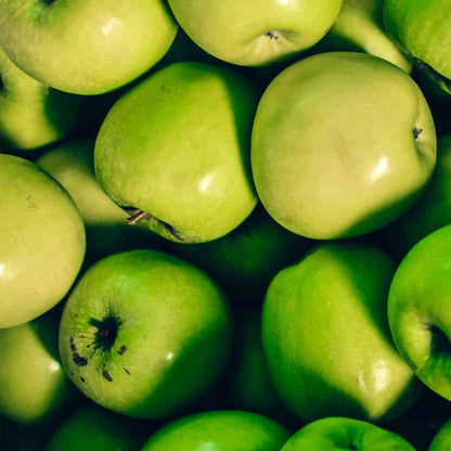 Fresh green Granny Smith apples packed tightly together