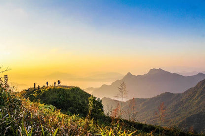 Panoramic mountain sunrise view with hikers on a peak, evoking fresh outdoor scents for scent marketing inspiration