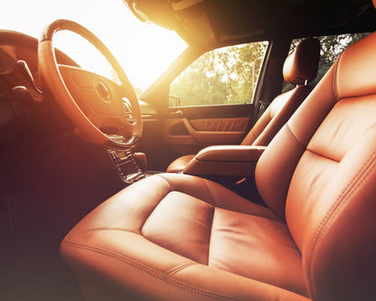 Luxury tan leather car interior with warm sunlight, ideal for automotive scent diffuser use
