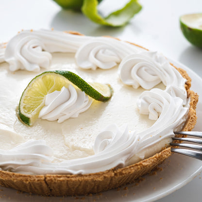 Key lime pie with whipped cream swirls and fresh lime slice garnish
