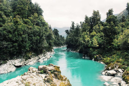 Turquoise river flowing through lush green forest gorge