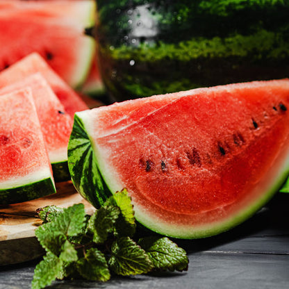 Fresh sliced watermelon with mint leaves on a wooden board